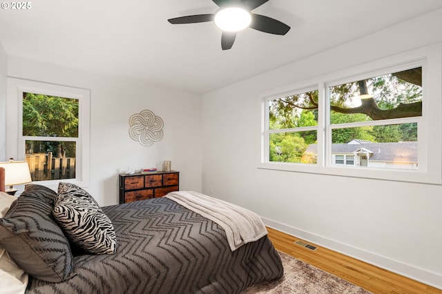 7170 SW 76th Ave, Portland, OR 97223 - bedroom with multiple windows, wood finished floors, and ceiling fan