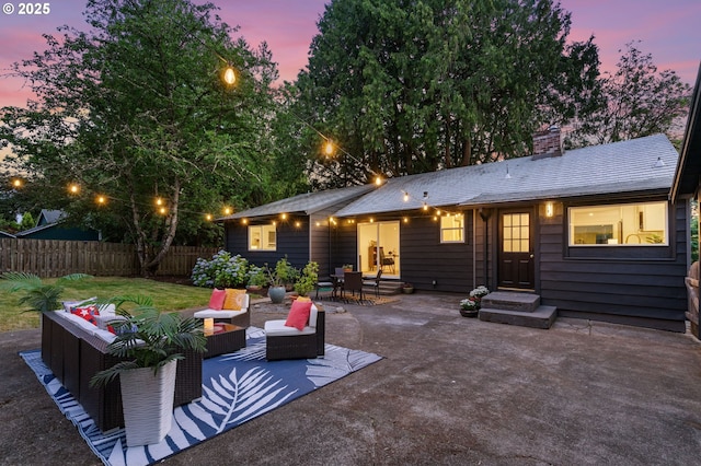 7170 SW 76th Ave, Portland, OR 97223 - back of house at dusk with a patio, outdoor lounge area, a chimney, and entry steps