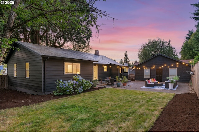 7170 SW 76th Ave, Portland, OR 97223 - back of property at dusk with a patio area, an outdoor hangout area, and a chimney