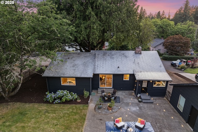 7170 SW 76th Ave, Portland, OR 97223 - back of house at dusk featuring a patio, a chimney, and entry steps