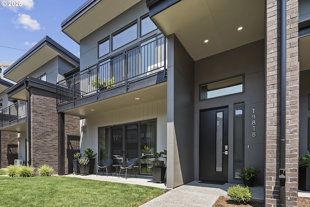 property entrance featuring a lawn and brick siding