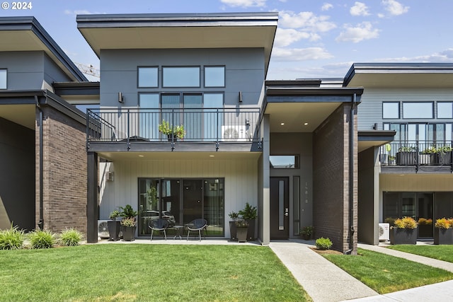 exterior space featuring a balcony and a front yard