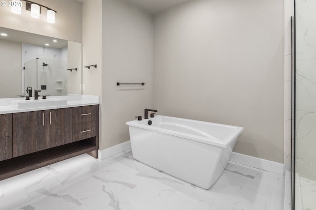 full bath with marble finish floor, baseboards, a soaking tub, and vanity