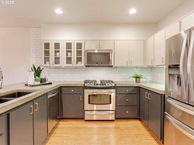 kitchen featuring gray cabinets, white cabinets, backsplash, and appliances with stainless steel finishes