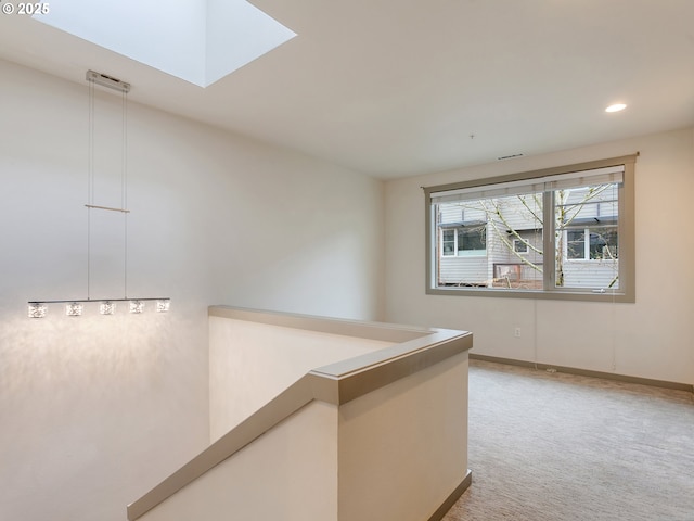 hall with a skylight and light carpet