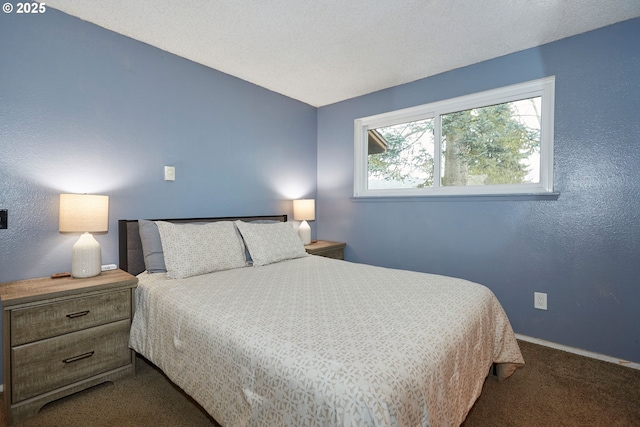 bedroom featuring baseboards, dark colored carpet, a textured wall, and a textured ceiling