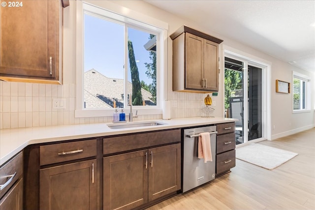 kitchen with backsplash, dishwasher, light hardwood / wood-style floors, and sink