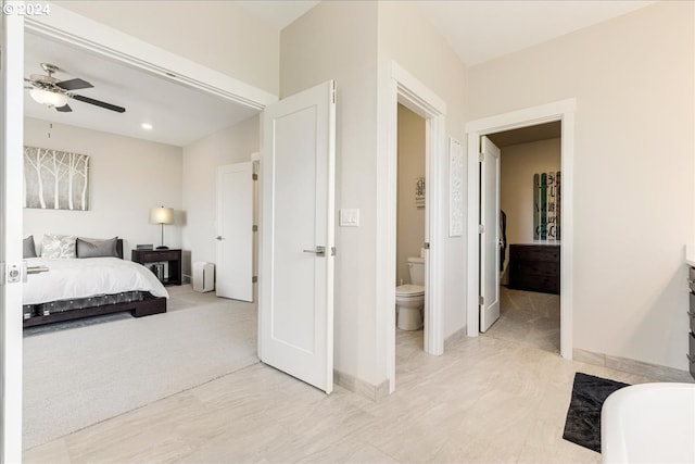 carpeted bedroom with ceiling fan and ensuite bath