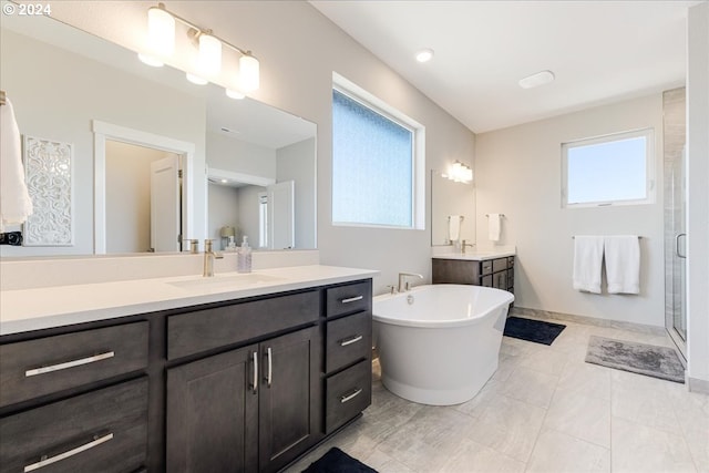 bathroom with tile patterned floors, vanity, and plus walk in shower