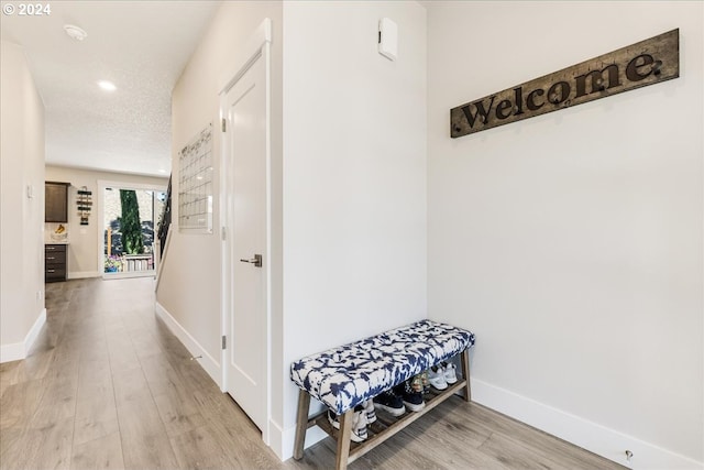 hallway featuring wood-type flooring and a textured ceiling