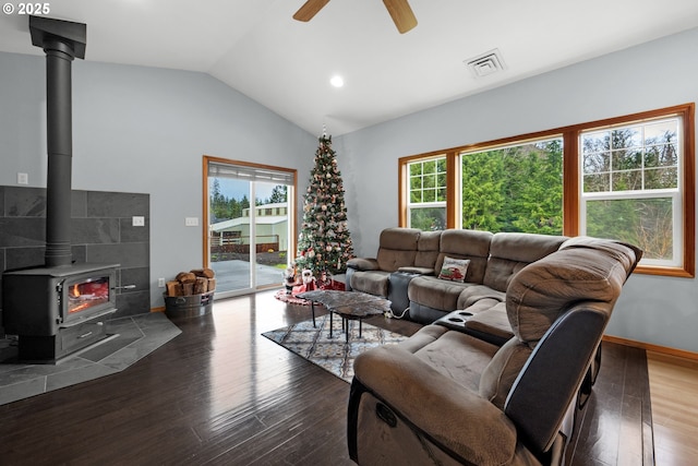 living room featuring a wood stove, ceiling fan, lofted ceiling, and hardwood / wood-style flooring