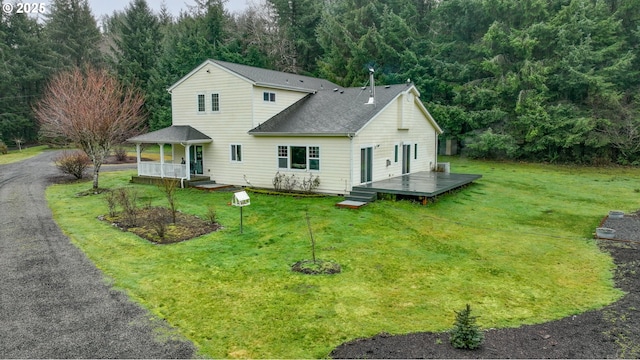 view of front facade with covered porch, a deck, and a front yard