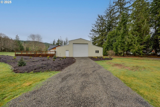 view of home's exterior with a lawn, a mountain view, an outdoor structure, and a garage