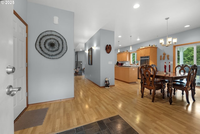 dining area with an inviting chandelier, a healthy amount of sunlight, and light wood-type flooring