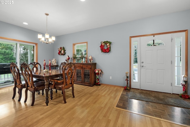 dining area featuring plenty of natural light, light hardwood / wood-style floors, and an inviting chandelier