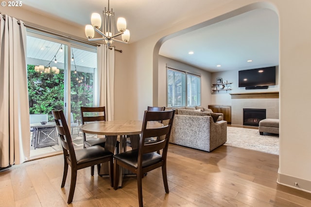 8326 SW Oak St, Portland, OR 97223 - dining room with arched walkways, a tile fireplace, light wood-style floors, a chandelier, and recessed lighting