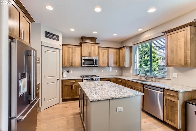 8326 SW Oak St, Portland, OR 97223 - kitchen featuring appliances with stainless steel finishes, light wood-type flooring, decorative backsplash, a center island, and recessed lighting