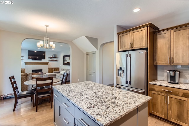 8326 SW Oak St, Portland, OR 97223 - kitchen featuring stainless steel refrigerator with ice dispenser, arched walkways, light wood-style floors, a chandelier, and a kitchen island