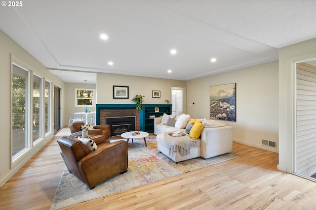 9080 SW Brier Ln, Portland, OR 97223 - living area featuring wood finished floors, a brick fireplace, recessed lighting, and baseboards