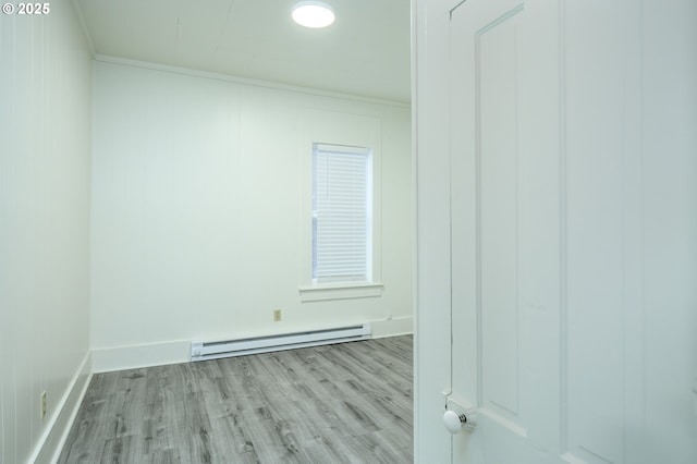 unfurnished room featuring crown molding, light hardwood / wood-style floors, and a baseboard heating unit