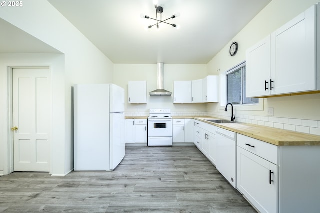 kitchen with white appliances, white cabinetry, wall chimney exhaust hood, and sink