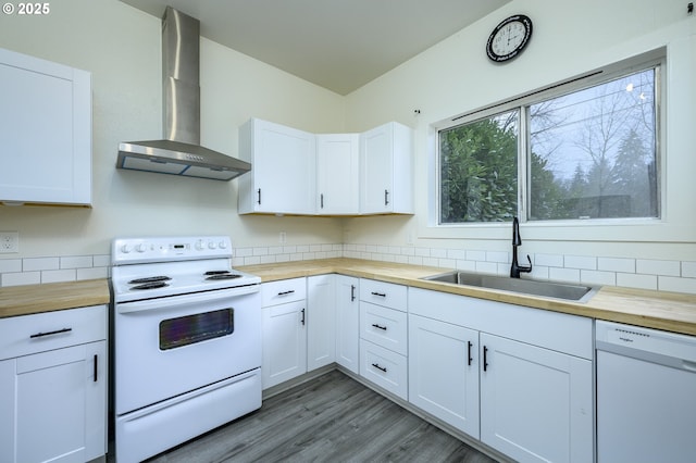 kitchen with white cabinetry, wall chimney exhaust hood, white appliances, and wood counters