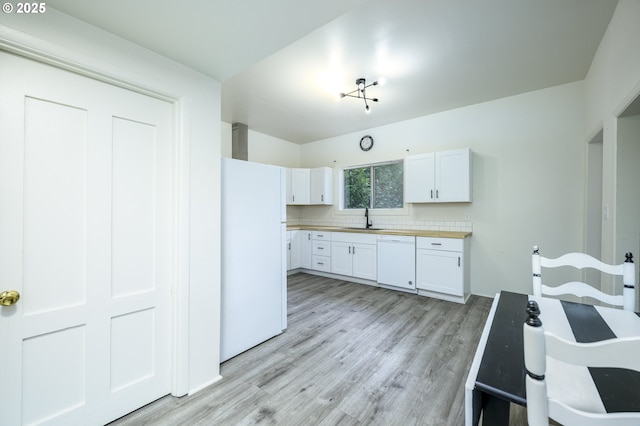 kitchen featuring decorative backsplash, white appliances, white cabinetry, and sink