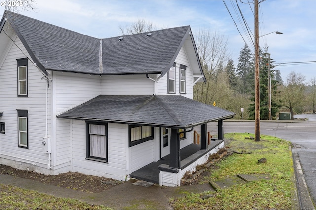 view of side of property featuring covered porch