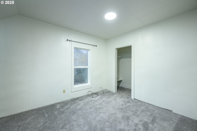 unfurnished bedroom featuring carpet flooring and lofted ceiling