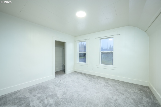 empty room with carpet floors and lofted ceiling