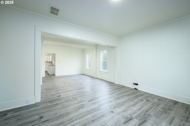 spare room featuring light hardwood / wood-style flooring and ornamental molding