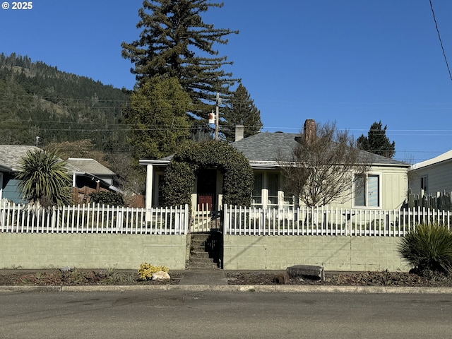 view of front of home with a fenced front yard and a porch