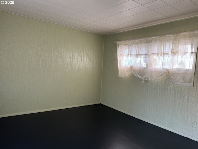 unfurnished room featuring baseboards