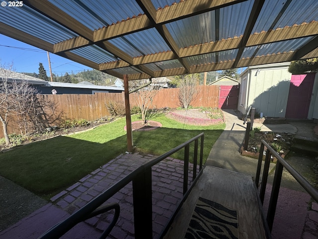 view of patio / terrace featuring a fenced backyard, a shed, and an outbuilding