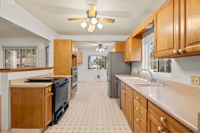 kitchen featuring a ceiling fan, light floors, a sink, light countertops, and appliances with stainless steel finishes