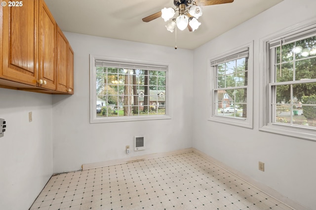 interior space featuring light floors, baseboards, and a ceiling fan