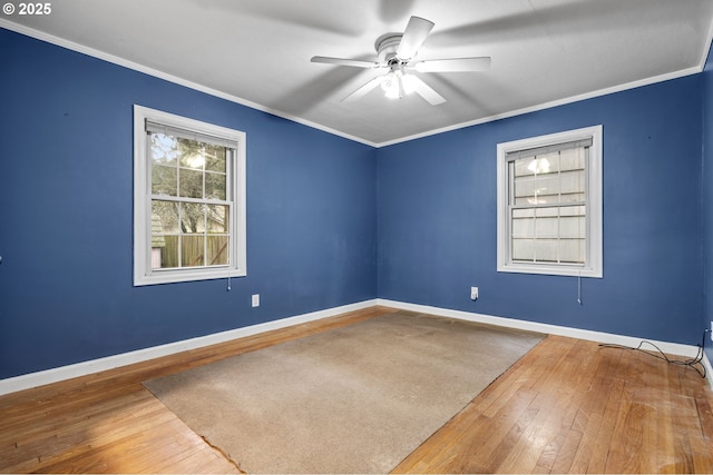 empty room featuring baseboards, hardwood / wood-style flooring, a ceiling fan, and ornamental molding