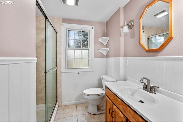 full bathroom featuring a shower stall, visible vents, tile patterned floors, and wainscoting