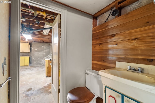 bathroom with vanity, toilet, and concrete flooring