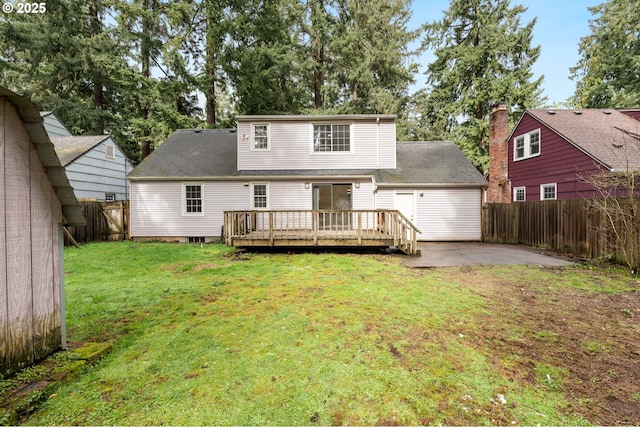 back of property featuring a shingled roof, a yard, a fenced backyard, a deck, and a patio