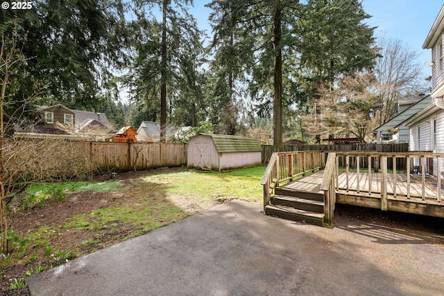 view of yard featuring a patio, an outdoor structure, a fenced backyard, and a storage shed