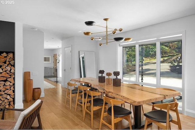 dining area with light wood-style flooring and a chandelier