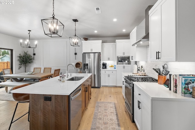 507 Honeysuckle Ln, Eugene, OR 97401 - kitchen featuring appliances with stainless steel finishes, wall chimney exhaust hood, a sink, a chandelier, and backsplash