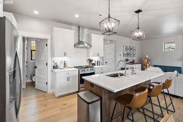 507 Honeysuckle Ln, Eugene, OR 97401 - kitchen featuring wall chimney range hood, stainless steel appliances, a sink, light wood-style flooring, and recessed lighting