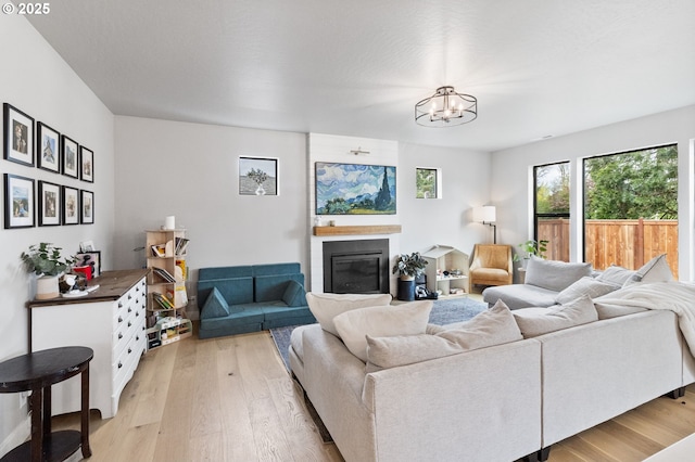 507 Honeysuckle Ln, Eugene, OR 97401 - living room with light wood-style floors, a chandelier, and a glass covered fireplace