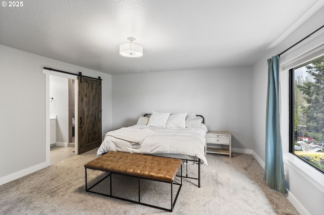 507 Honeysuckle Ln, Eugene, OR 97401 - carpeted bedroom featuring a barn door, connected bathroom, and baseboards