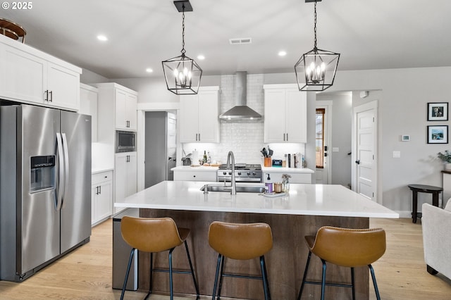 507 Honeysuckle Ln, Eugene, OR 97401 - kitchen with stainless steel appliances, wall chimney range hood, a chandelier, a kitchen breakfast bar, and recessed lighting