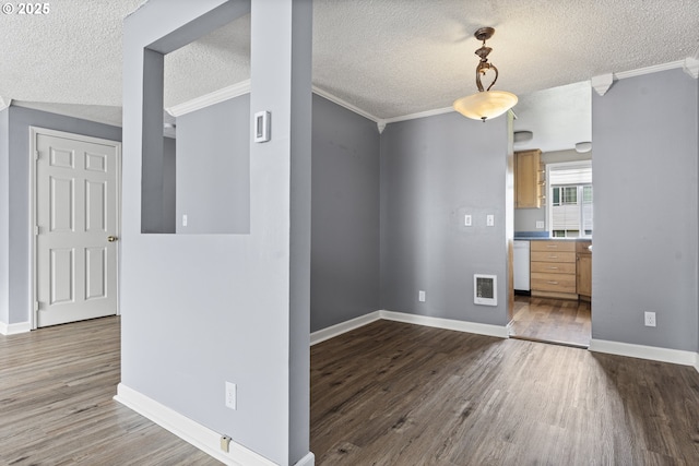 unfurnished dining area with dark wood-type flooring, baseboards, crown molding, and a textured ceiling