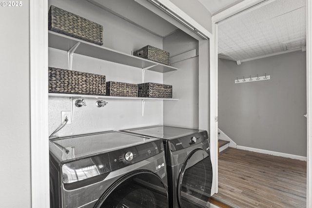 laundry area with washer and dryer, laundry area, wood finished floors, and baseboards