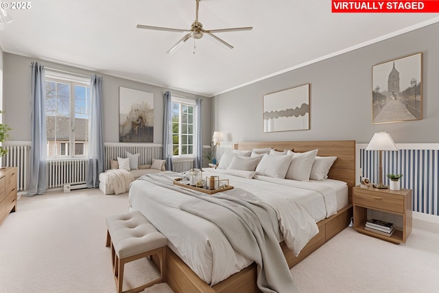carpeted bedroom featuring crown molding, radiator, and a ceiling fan